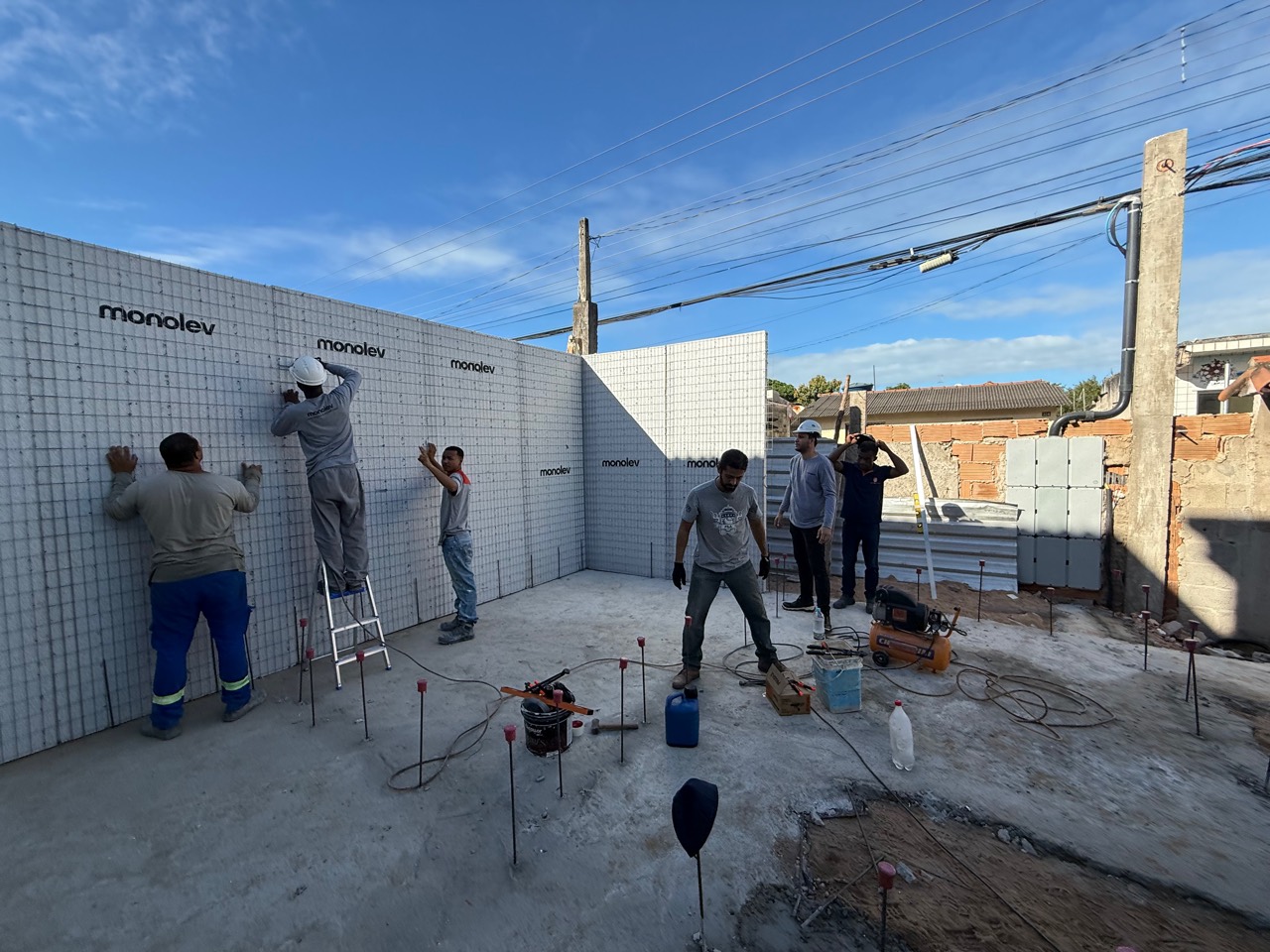 Equipe instalando painéis monolíticos em obra real