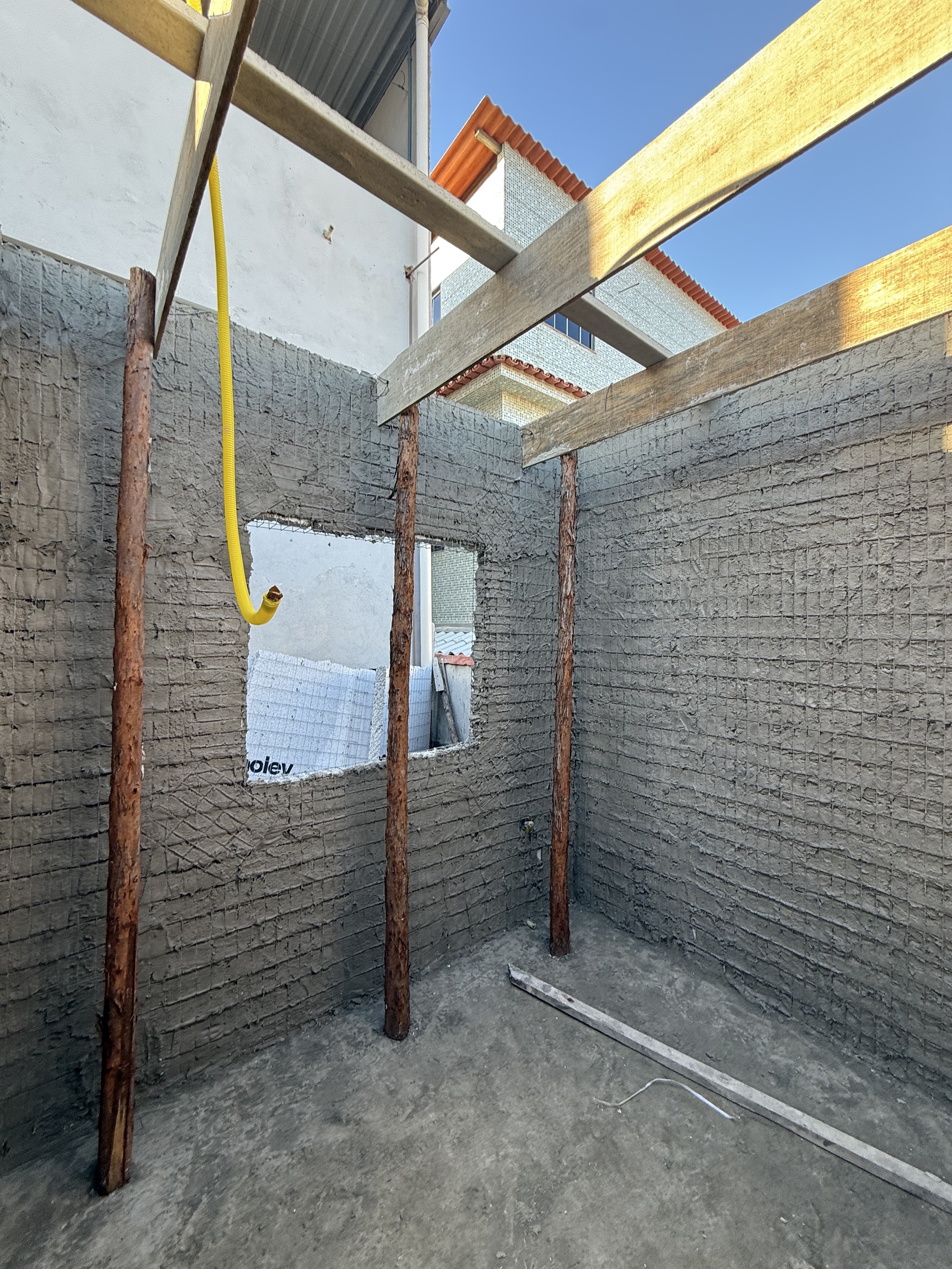 Eletroduto amarelo instalado em uma parede monolítica da obra real